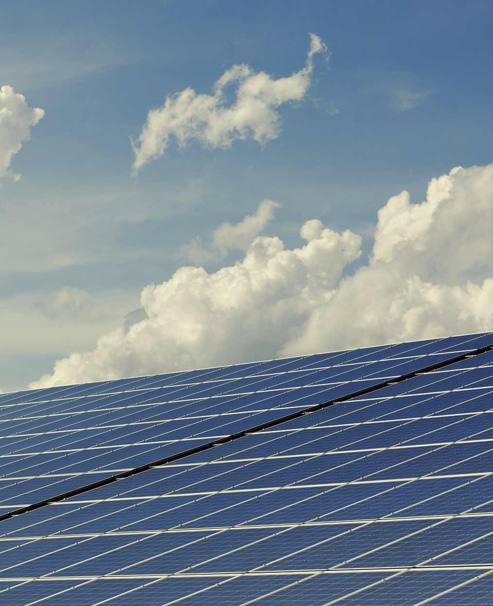 The Future in Renewable Energy Solar panels in front a bright slightly cloudy sky.